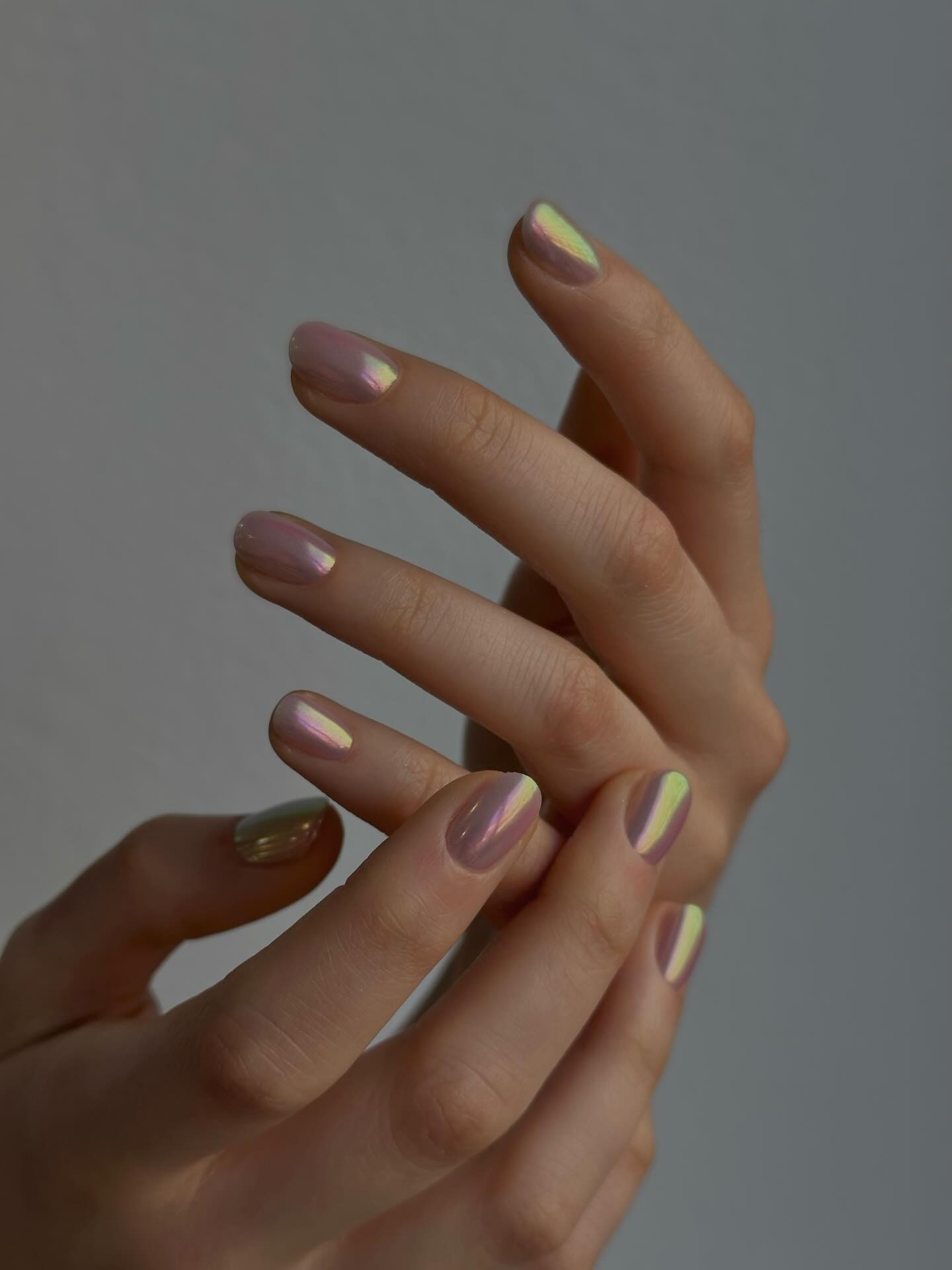 Manos entrelazadas con manicura francesa en lavanda y amarillo pastel, diseño vertical bicolor